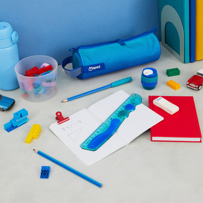 Blue stationery set featuring a textured sensory ruler, pencil case, and pencils on a desk with colorful toys.
