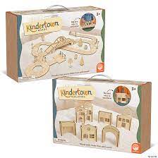 Two boxes of Kindertown solid wood toys: a winding road set and a collection of miniature town buildings and arches.