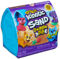 Blue dog house-shaped container with a label featuring colorful cartoon dogs playing on a sandy beach.
