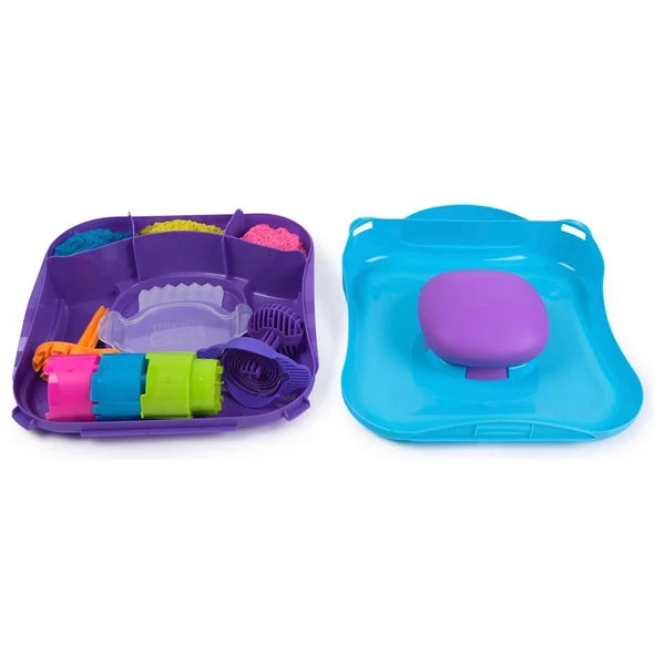 Purple and blue play trays containing bright pink, yellow, and blue kinetic sand with various colorful molds and tools.
