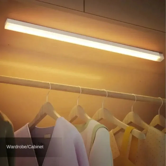 Kitchen Rechargeable Lamp LED Light With Motion Sensor illuminating a wardrobe area with clothes hanging in a closet.