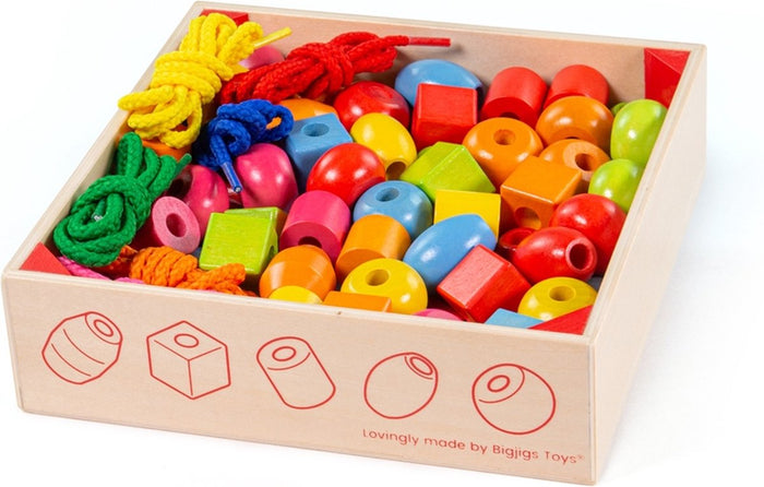 Colorful wooden beads in various shapes and matching laces in a wooden tray with bead shape diagrams.