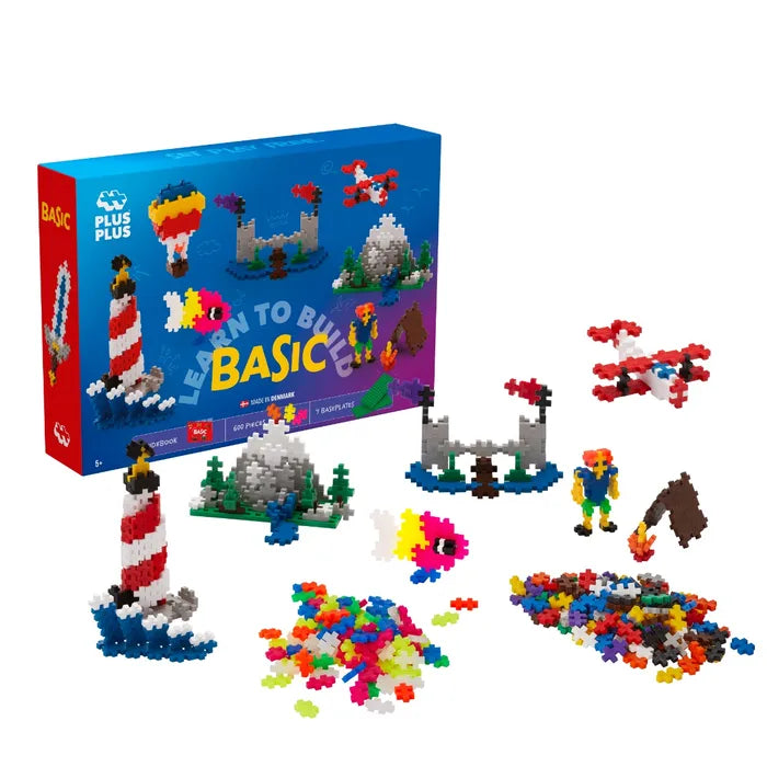 Blue toy box with colorful plus-shaped blocks and built models of a red and white lighthouse, castle, and airplane.