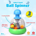 Clear dome toy with blue plunger and green base. Three colorful balls inside spin over glowing orange lights.