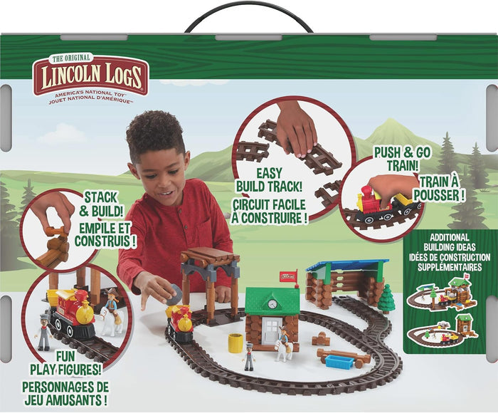 Toy box showing a child playing with brown logs, a red train on a track, and tiny figures against a green background.