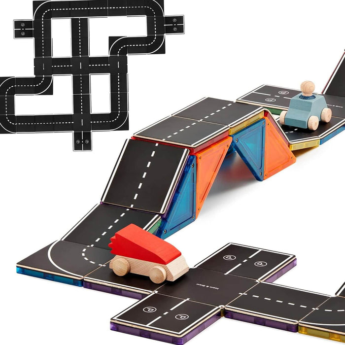 Black road-patterned magnetic tile toppers on colorful translucent tiles forming a bridge and track with toy cars.