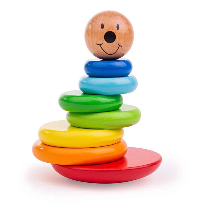 Wooden stacking toy with rainbow rings and a smiley face topper on a rounded red wobbly base.