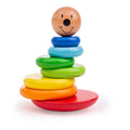 Wooden stacking toy with rainbow rings and a smiley face topper on a rounded red wobbly base.