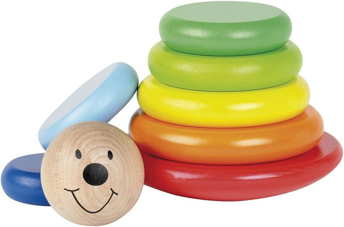 Colorful wooden rings stacked in a pyramid next to a blue ring and a round smiling face piece.