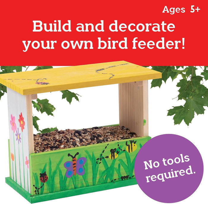 Wooden bird feeder with yellow roof and garden art. Text: Ages 5+, build and decorate, no tools required.