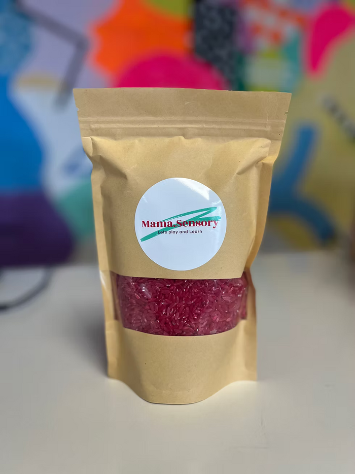 Brown paper pouch with a window showing dark pink rice and a white circular Mama Sensory logo sticker.
