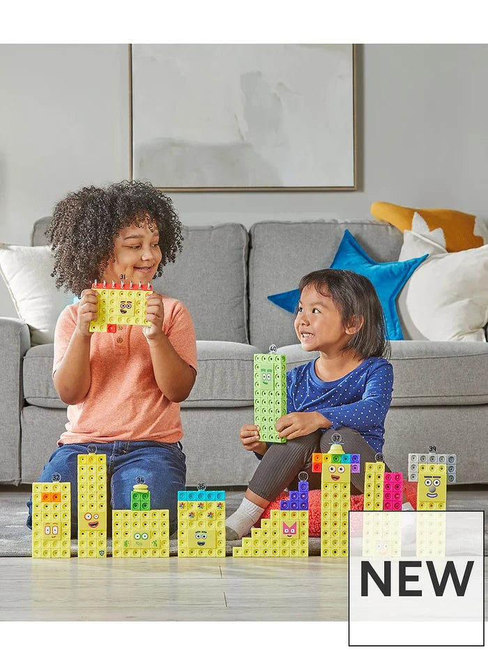 Two kids play with yellow Numberblocks characters 31-40 made of interlocking MathLink cubes on a living room rug.