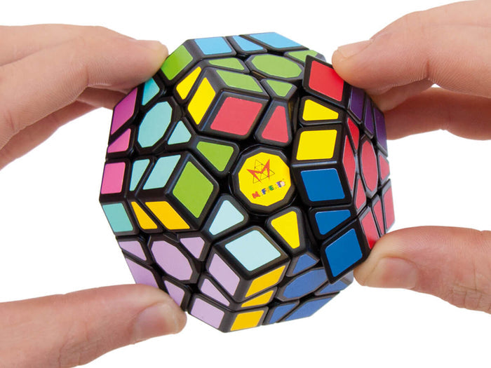Hands holding a black dodecahedron puzzle featuring colorful stickers on its multiple geometric faces.