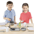 Two children play with a variety of grey and white toy kitchen accessories including pots, pans, and plates.