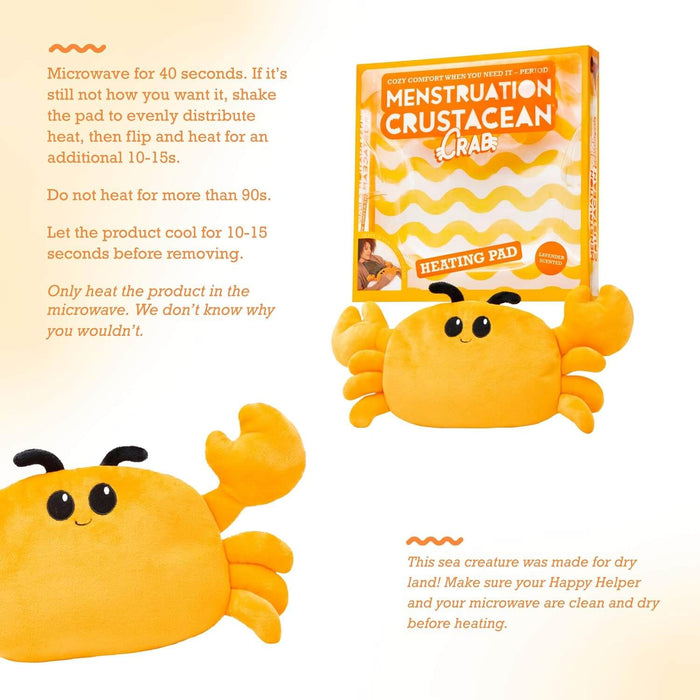 Smiling yellow plush crab heating pad with its orange box and microwave instructions. It has black eyes and a cute face.