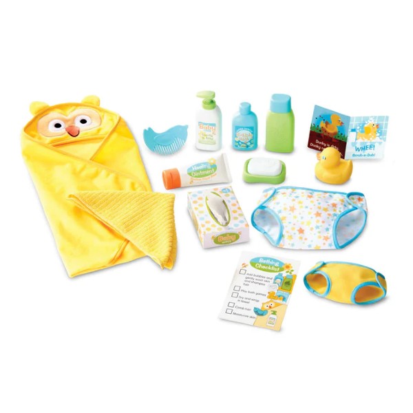 Doll bath set featuring a yellow owl towel, rubber ducky, star-patterned diaper, and colorful pretend toiletries.