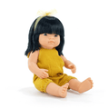Sitting doll with straight black hair and bangs, wearing a yellow bow and a mustard yellow textured romper.