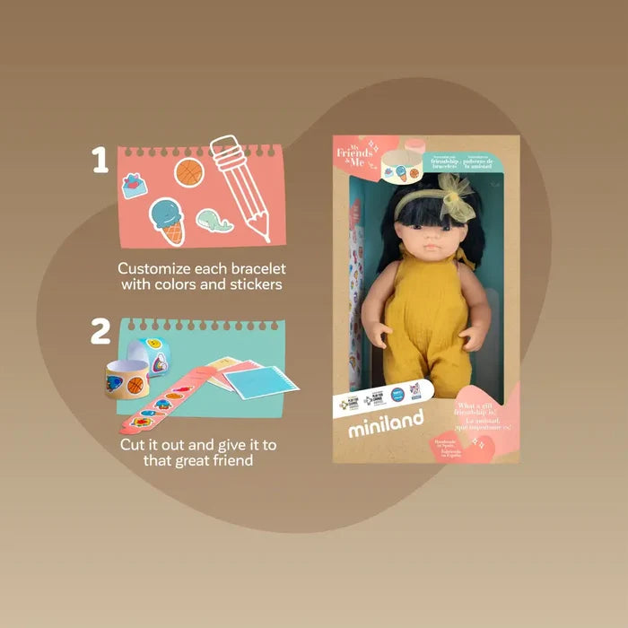 Boxed Asian doll in a yellow jumpsuit next to instructions for making and decorating paper friendship bracelets.