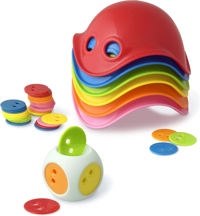 Six nested rainbow-colored shells, a white die, and stacks of colorful round game buttons on a white background.