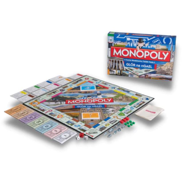 Monopoly board game in Irish with blue box, board featuring scenic photos, property cards, paper money, and game tokens.