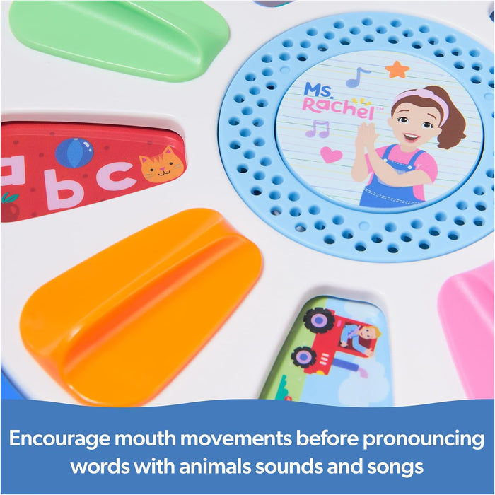 Close-up of a white toy wheel with a blue center featuring Ms. Rachel and colorful levers with letters and icons.
