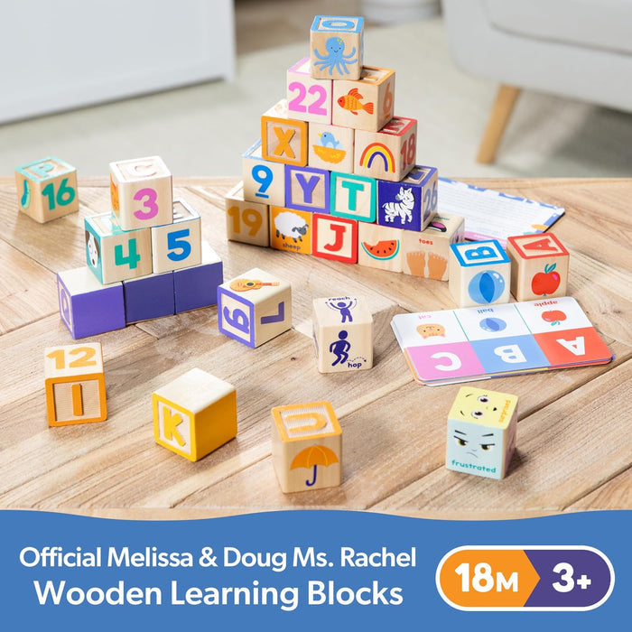 Colorful wooden blocks with letters and numbers stacked beside activity cards on a wooden tabletop.