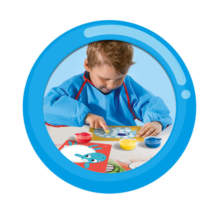 Young boy in a blue smock finger painting animal cards with red, yellow, and blue paint pots.