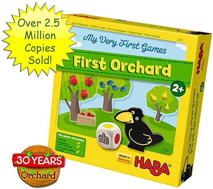 Yellow Haba game box for First Orchard with illustrations of a raven, colorful fruit trees, and a large wooden die.