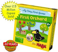 Yellow Haba game box for First Orchard with illustrations of a raven, colorful fruit trees, and a large wooden die.