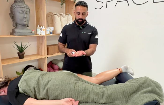 A physical therapist dispensing NAQI Recovery Gel into his hand, purchased through Massage Warehouse, trusted partner for bodywork practitioners in the UK and Ireland; emphasizes the fast-absorbing, non-greasy formula with vanilla butter ether engineered to boost circulation and flush waste materials post-exercise in Derry.