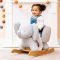 Soft gray plush elephant rocker with a built-in seat and light wood base, shown with a child riding.