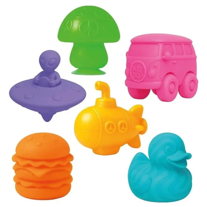 Six colorful squishy toys: green mushroom, pink van, purple alien saucer, yellow submarine, orange burger, and blue duck.