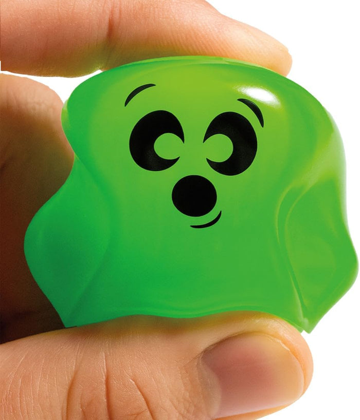 Hand squeezing a small neon green squishy toy with a cute black cartoon face.