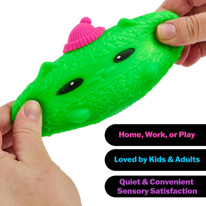 Hands stretch a bright green cat-shaped squishy toy with a knitted sweater texture and a small pink hat.