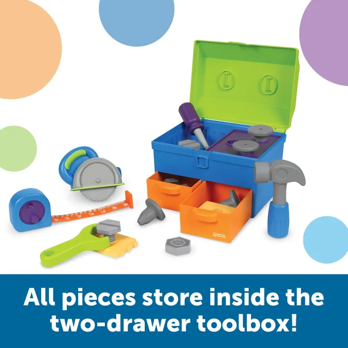 Colorful plastic toy tool set with hammer, saw, and wrench around a blue and green toolbox with orange drawers.