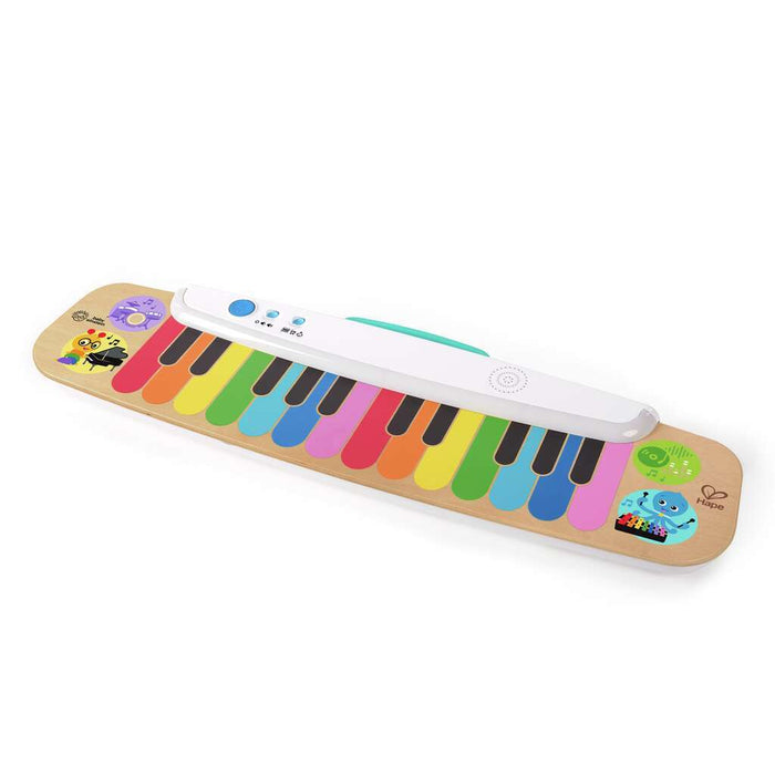 Flat wooden toy keyboard with rainbow keys, a white electronic control bar, and colorful character illustrations.