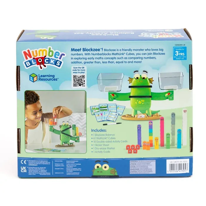 Back of blue packaging showing a green monster-shaped balance, colorful cubes, and a child playing with activity cards.