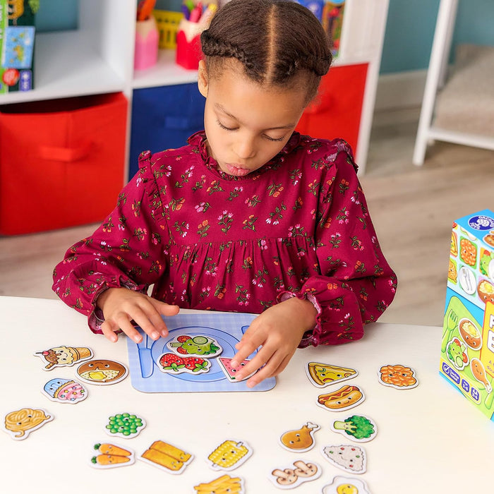 A girl plays with colourful cartoon food pieces and a blue place-setting board from the Fun Food Bingo game.