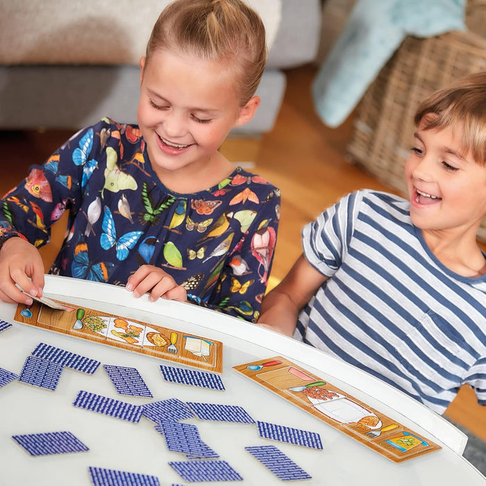 Smiling children playing a matching game with colorful food meal boards and blue-patterned square tiles.