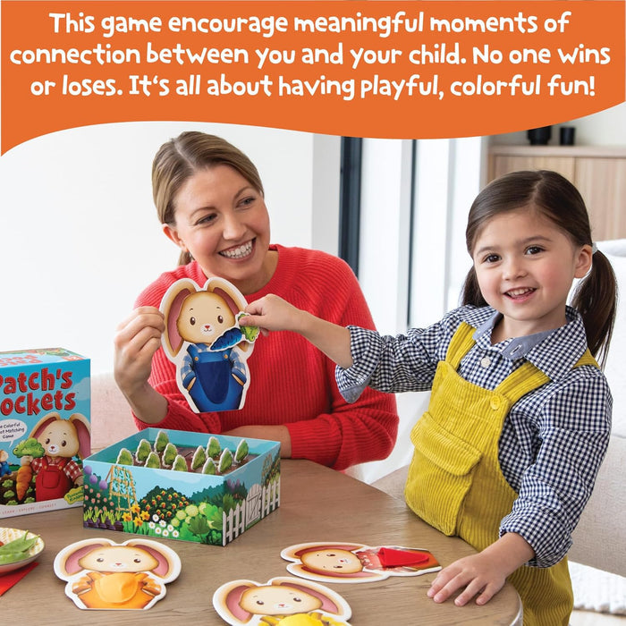 A mother and child play with colorful rabbit-shaped cards and a garden-themed box on a wooden table.