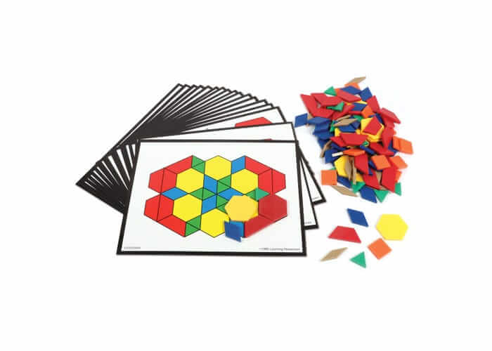 Colorful plastic hexagons, triangles, and diamonds next to a stack of cards featuring geometric pattern outlines.