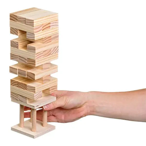 Tall light-wood block tower on a square pillared base. A hand reaches to remove a rectangular block.