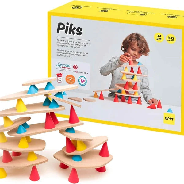 Piks construction set featuring wooden planks and colorful cones next to a yellow box with a child playing.