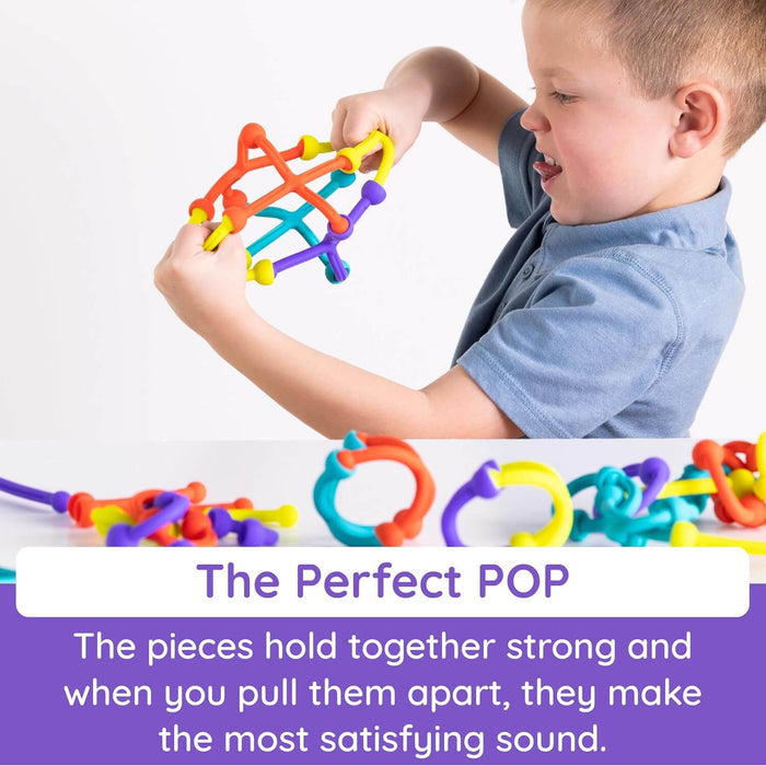 Boy pulls apart a colorful suction cup toy lattice. Vibrant orange, yellow, and teal pieces with The Perfect POP text.