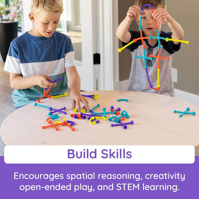 Two children playing with colorful, flexible suction building rods at a table. Text says Build Skills.