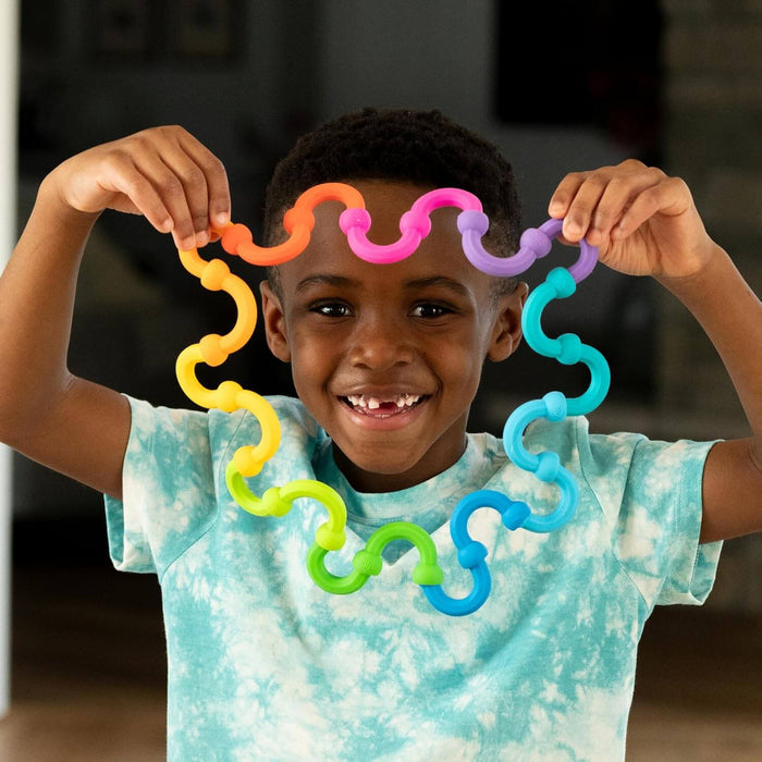 Smiling child holding a circular chain of colorful, curved interlocking toy links around their face.
