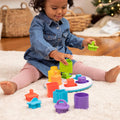 Toddler playing with colorful shape sorter toy on white rug with bright chunky blocks and a round white base.