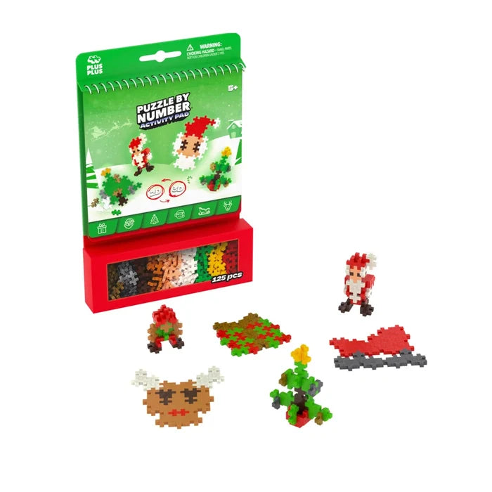 Plus Plus Christmas activity pad with green spiral book, red piece tray, and holiday-themed brick figures.