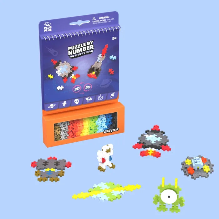 Blue space activity pad and 125 colorful plus-shaped pieces with assembled rocket, astronaut, and green alien models.