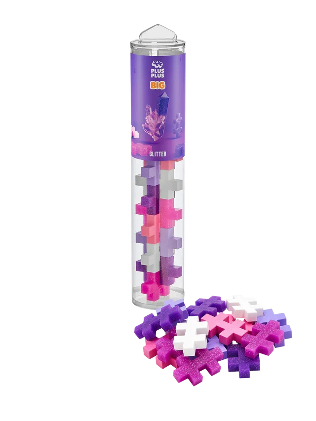 Clear tube of pink, purple, and white plus-sign building blocks with scattered pieces, some with a glitter finish.